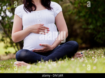 Gesichtslose schwangere Frau im Park Stockfoto