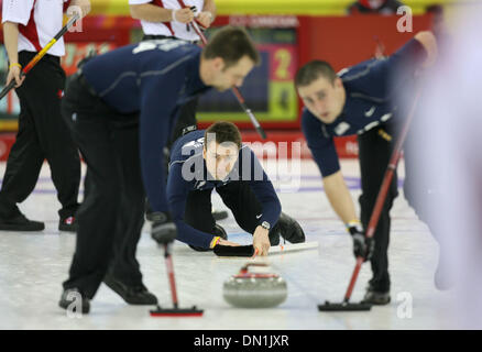 22. Februar 2006; Pinerolo, Italien; Die US-Männer Curling Team verlor ihr Halbfinale Spiel nach Kanada 11-5 Mittwoch Nacht in Pinerolo Palaghiaccio. Sie werden für die Bronze-Medaille am Freitag spielen. Foto zeigt: PETE FENSON Uhren die Lieferung des Felsens am fünften Ende während Teamkollegen SHAWN ROJESKI, links, und JOE POLO den Weg frei. Obligatorische Credit: Foto von Jeff Wheeler/Minneapol Stockfoto