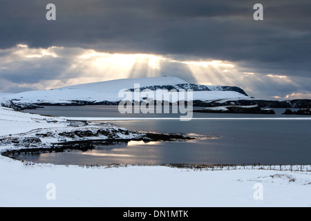 Wintersonne bricht durch die Wolken über eine verschneite St. Ninian Isle und unruhigen Kopf, Shetland, Scotland, UK Stockfoto