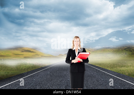 Zusammengesetztes Bild der Geschäftsfrau lächelnd und hält Ordner Stockfoto