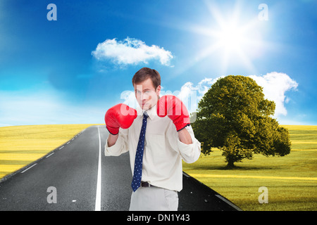 Zusammengesetztes Bild der Geschäftsmann mit seinem Boxhandschuhe bereit zu kämpfen Stockfoto