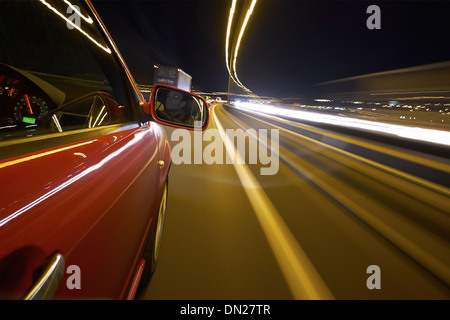 Ein Mann, Autofahren in der Nacht auf einem stark frequentierten Autobahn. Stockfoto