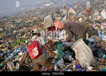 Ein junges Kind Arbeiter junge trägt einen Rucksack während der Arbeit an der Stung Meanchey Deponie in Phnom Penh, Kambodscha. Stockfoto