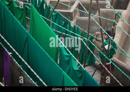 Mumbai, Indien. 18. Dezember 2013. Ein Arbeiter trocknet die Kleidung am Dhobi Ghat in Mumbai, Indien, 18. Dezember 2013. Dhobi Ghat, mit mehr als 150 Jahren Geschichte, findet in der Innenstadt von Mumbai. Es wird als die weltweit größte Open-Air-Waschsalon aufgezeichnet. Die Unterlegscheiben, lokal bekannt als Dhobis, arbeiten im Freien für Besitzer der Teiche Wäsche zum Waschen der Kleidung von Mumbais Hotels und Krankenhäuser. Sie Leben mit ihrer Familie in den Dhobi Ghat, Hunderte von indischen Rupien pro Tag zu verdienen. © Zheng Huansong/Xinhua/Alamy Live-Nachrichten Stockfoto