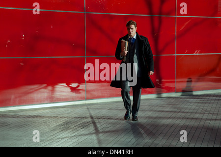 Geschäftsmann am Weg zur Arbeit auf rotem Grund Stockfoto