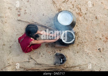 Junge Inderin Warmhalten von offenem Feuer in einem indischen Dorf. Andhra Pradesh, Indien Stockfoto