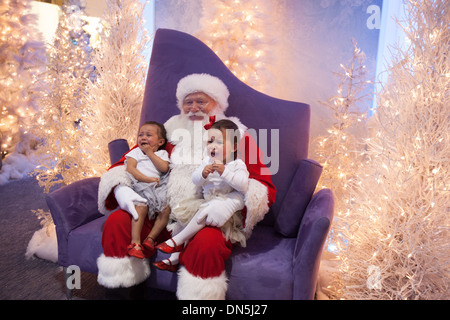 Santa Claus Posen mit schreienden Babys auf dem Eis-Palast-Weihnachtsmarkt anzeigen im Beverly Center in Los Angeles, CA Stockfoto