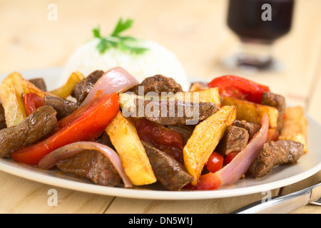 Peruanische Gericht namens Lomo Saltado gemacht von Rindfleisch, Tomaten, roten Zwiebeln und Pommes frites, serviert mit Reis Stockfoto