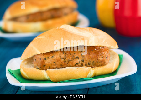 Gebratene Bratwurst im Brötchen, serviert traditionelle deutsche Fast-Food auf Einweg-Teller mit Serviette, Ketchup und Senf in den Rücken Stockfoto