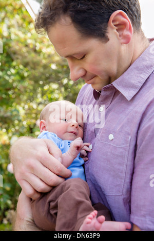 Vater Holding neugeborenen Sohn im freien Stockfoto