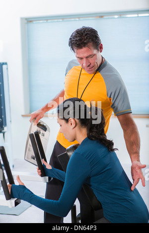 Frau arbeitet mit personal Trainer im Fitness-Studio Stockfoto