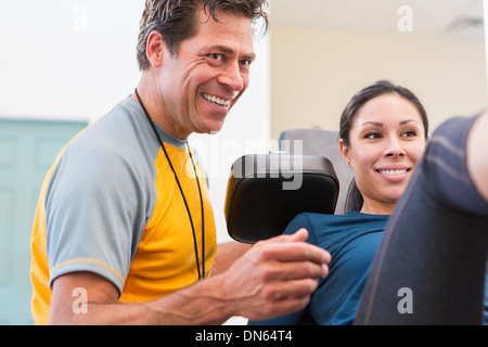 Frau arbeitet mit personal Trainer im Fitness-Studio Stockfoto