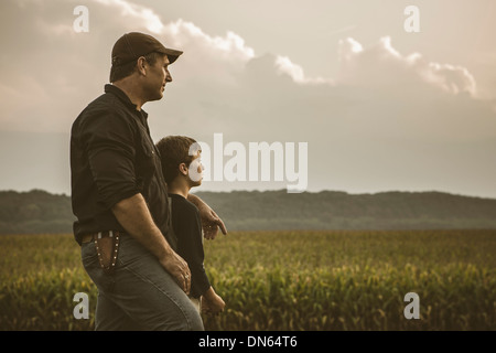 Kaukasische Vater und Sohn mit Blick auf Getreidefelder Stockfoto