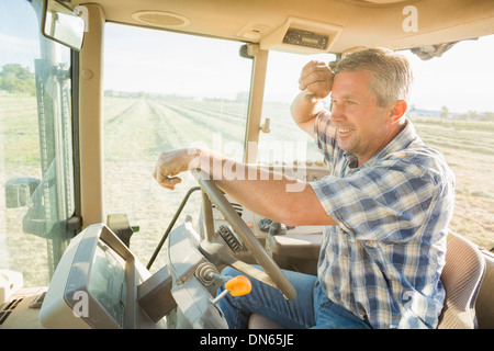 Kaukasische Landwirt treibende Traktor Stockfoto