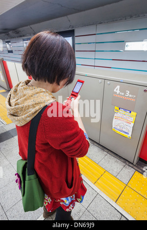Honshu, Kanto, Tokio, Japan, U-Bahn-Fahrgast Blick auf Handy Stockfoto