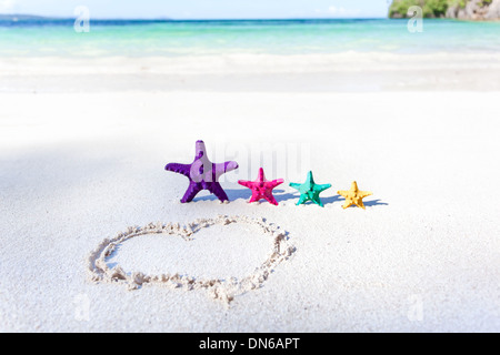 Herz am Strand mit Farbe Seesterne, romantisches Konzept Stockfoto