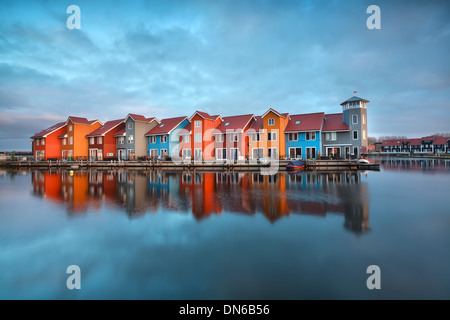 bunte Gebäude auf dem Wasser bei Sonnenaufgang, Groningen, Niederlande Stockfoto