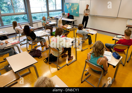 Lehrer im Schulraum spricht mit Schülerinnen Stockfoto