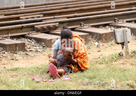 Eine obdachlose Liebe der Mutter ihrem Baby an Kamalapur Bahnhof in Dhaka am 19. Dezember 2013. Stockfoto