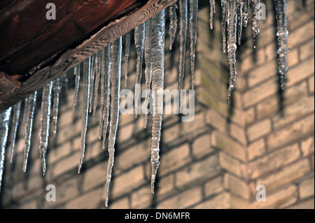 Lange Eiszapfen hängen von der Seite eines Gebäudes in Kanada. Stockfoto