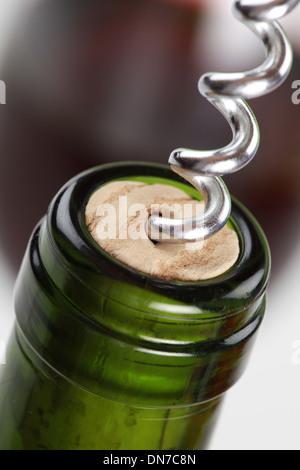 Nahaufnahme einer Weinflasche mit Rotwein und einem Korkenzieher Stockfoto