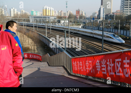 Die Menschen gehen auf einer Überführung während HSR Zug Südbahnhof Peking in Peking verlassen wird. 15. Dezember 2013 Stockfoto