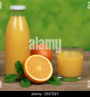 Frische Orangen und Orangensaft auf einem Holztisch Stockfoto