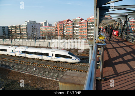 Die Menschen gehen auf einer Überführung während HSR Zug Südbahnhof Peking in Peking verlassen wird. 15. Dezember 2013 Stockfoto