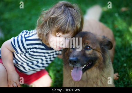 Kleiner Junge kuschelt mit Hund Stockfoto