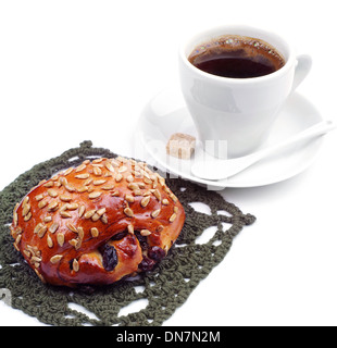 Brötchen mit Rosinen und Sonnenblumenkerne mit Kaffeetasse auf weißem Hintergrund Stockfoto