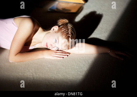 Junge Frau auf dem Boden liegend, Porträt Stockfoto