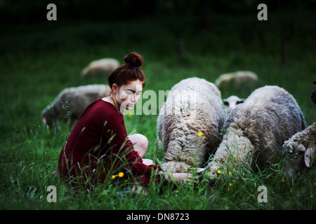 Junge Frau mit Schafe auf einer Wiese Stockfoto