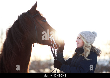 Junge Frau mit Pferd im winter Stockfoto