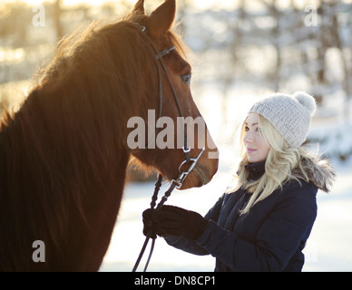 Junge Frau mit Pferd im winter Stockfoto