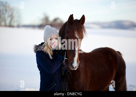 Junge Frau mit Pferd im winter Stockfoto