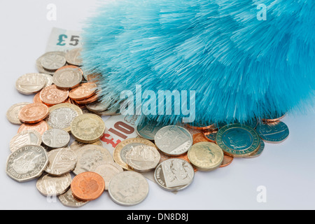 Ein Staubwedel Abstauben einen Haufen von Sterling Geld Münzen und Banknoten. England, Großbritannien, Großbritannien, Europa. Stockfoto