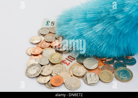 Ein Staubwedel Abstauben einen Haufen von Sterling Geld Münzen und Banknoten. England, Großbritannien, Großbritannien, Europa. Stockfoto