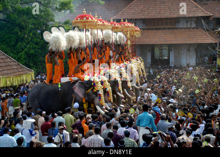 Caparisoned Elefanten dekoriert Gottheiten in goldenen Kolams eingebettet gehalten mit bunten Schirmen von thrissur pooram, kerala, indien, thrissur pooram Menge Stockfoto