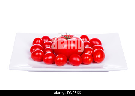 Frische Kirschtomaten auf Platte isoliert auf weißem Hintergrund Stockfoto