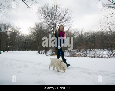 Teenager-Mädchen Spaziergang mit ihrem Hund an einem Wintertag Stockfoto