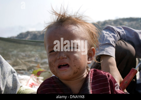 Ein junges Kind Arbeiter Junge weint in einer Müllkippe bei Stung Meanchey Mülldeponie in Phnom Penh, Kambodscha. Stockfoto