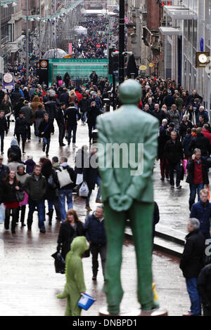 Buchanan Street, Glasgow City Centre, Schottland, UK, Samstag, 21. Dezember 2013. People Christmas Shopping in der Buchanan Street im Stadtzentrum von Glasgow während der britischen Wintersonnenwende und am letzten Samstag vor dem Weihnachtstag, bewacht von der Statue des ehemaligen Ersten Ministers Donald Dewar Stockfoto