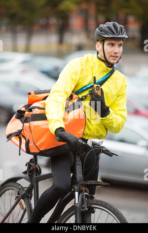 Männliche Radfahrer mit Kuriertasche mit Walkie-Talkie Stockfoto