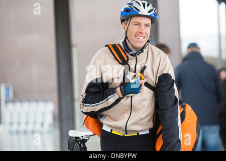 Männliche Radfahrer mit Kuriertasche mit Walkie-Talkie Stockfoto
