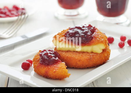 Panierte und gebackene Camembert mit Preiselbeersauce auf weißen Teller closeup Stockfoto