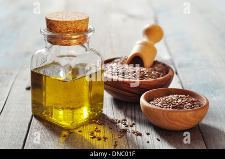 Leinsamen und Öl in der Flasche auf hölzernen Hintergrund Stockfoto