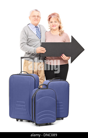 In voller Länge Portrait von einem lächelnden Reifen Touristen halten einen großen schwarzen Pfeil und Reisetaschen Stockfoto