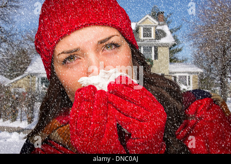 Schwer kranke Frau In fallenden Schnee weht ihre Wunde Nase mit Gewebe außerhalb. Stockfoto