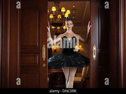 Ballerina in schwarz Tutu stehend in Tür in Luxus-Interieur Stockfoto