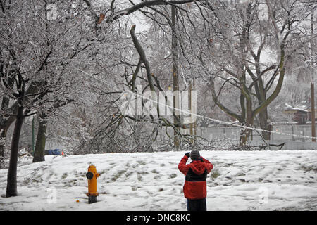 Toronto, Kanada. 22. Dezember 2013. Major Ice Storm und Gefrierender Regen verursachten Schäden an Stromleitungen und Bäume in Davisville Park in Midtown Toronto. Ein unbekannter Mann ist das Fotografieren. Bildnachweis: CharlineXia/Alamy Live-Nachrichten Stockfoto